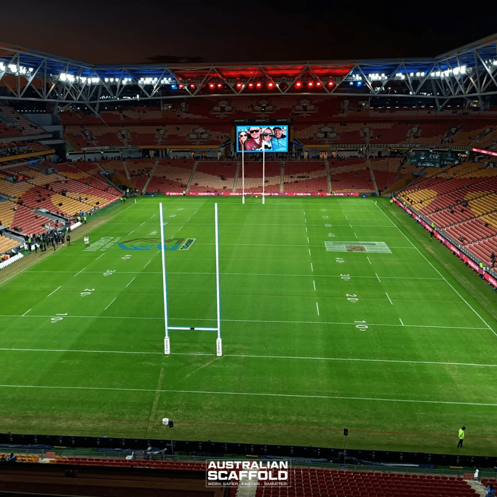 Aerial view of Lang Park Stadium at night, illuminated with bright lights